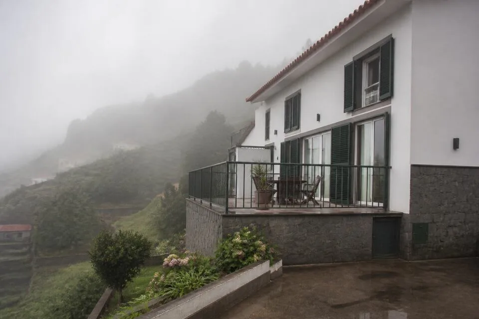 Home on a green Madeira hillside inside low cloud